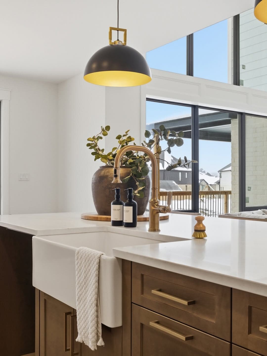 Kitchen island with brass fixtures and pendant lighting